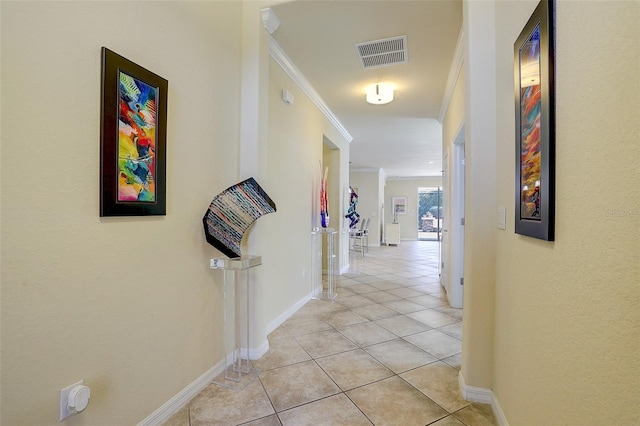 hall featuring ornamental molding and light tile patterned floors