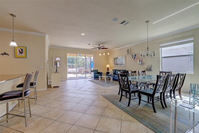 dining area with crown molding, ceiling fan with notable chandelier, and light tile patterned floors