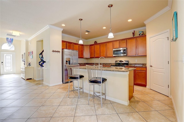 kitchen with sink, light tile patterned floors, stainless steel appliances, light stone countertops, and a center island with sink