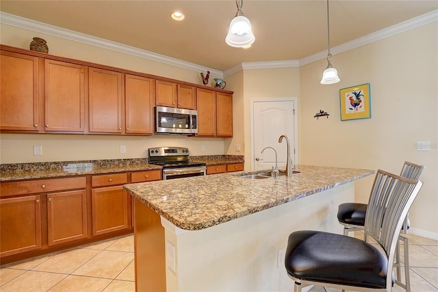 kitchen with sink, stainless steel appliances, a kitchen breakfast bar, and a center island with sink