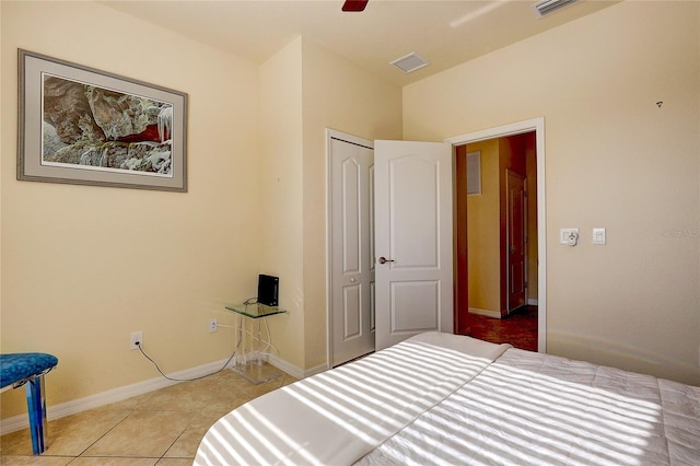 bedroom featuring light tile patterned flooring, ceiling fan, and a closet