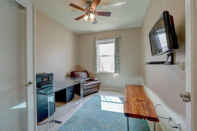 tiled office space featuring ceiling fan