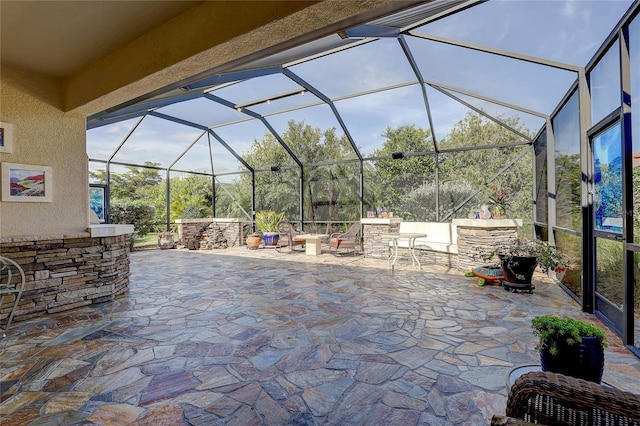 view of patio featuring exterior bar, a lanai, and exterior kitchen