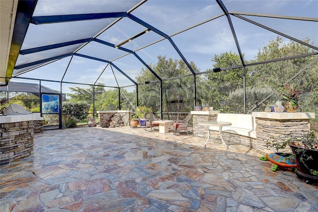 view of patio featuring an outdoor kitchen and a lanai