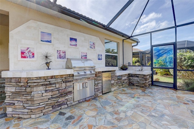 view of patio / terrace with an outdoor kitchen, sink, a lanai, and area for grilling