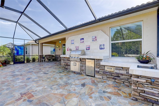 view of patio featuring area for grilling, sink, and glass enclosure