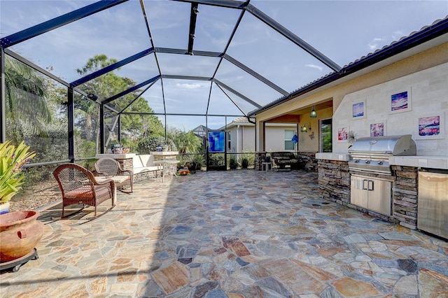 view of patio with a grill, exterior kitchen, and glass enclosure