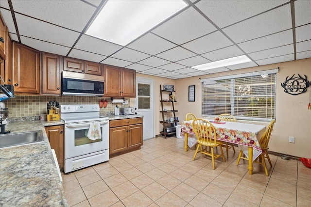 kitchen featuring light tile patterned flooring, backsplash, and electric range