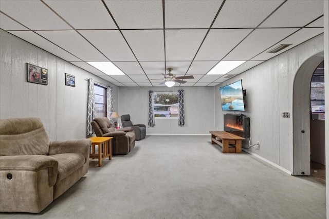 carpeted living room with ceiling fan and a fireplace