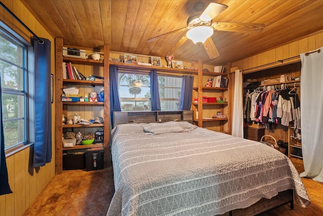 bedroom featuring wooden ceiling, wooden walls, a closet, and ceiling fan