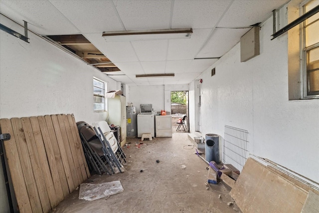 interior space with washing machine and dryer, a drop ceiling, and water heater