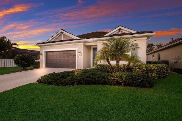 single story home featuring a garage and a yard