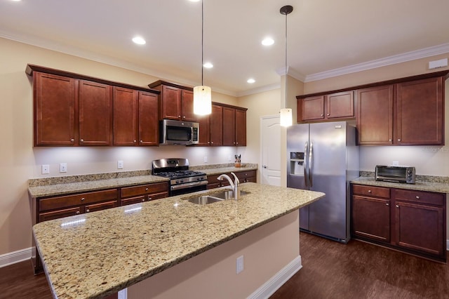 kitchen featuring light stone countertops, hanging light fixtures, appliances with stainless steel finishes, and an island with sink