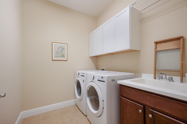 washroom with sink, washing machine and clothes dryer, cabinets, and light tile patterned flooring