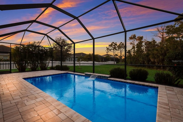 pool at dusk featuring pool water feature, a lanai, and a patio