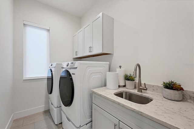 laundry area featuring cabinets, separate washer and dryer, sink, and light tile patterned floors