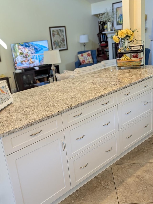 kitchen with white cabinetry and light stone countertops