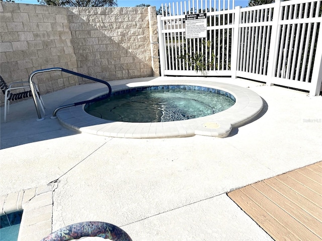 view of swimming pool with a hot tub