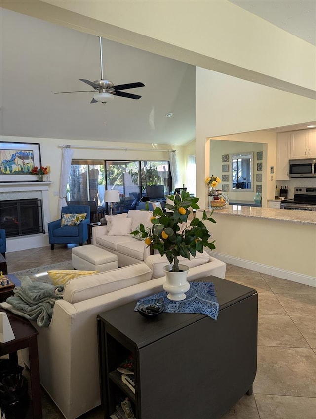 living room featuring light tile patterned floors, baseboards, lofted ceiling, and a glass covered fireplace