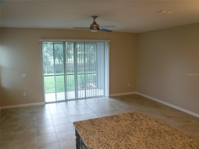 tiled spare room featuring ceiling fan