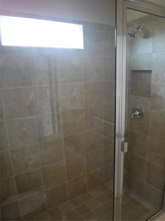 bathroom with a shower with door