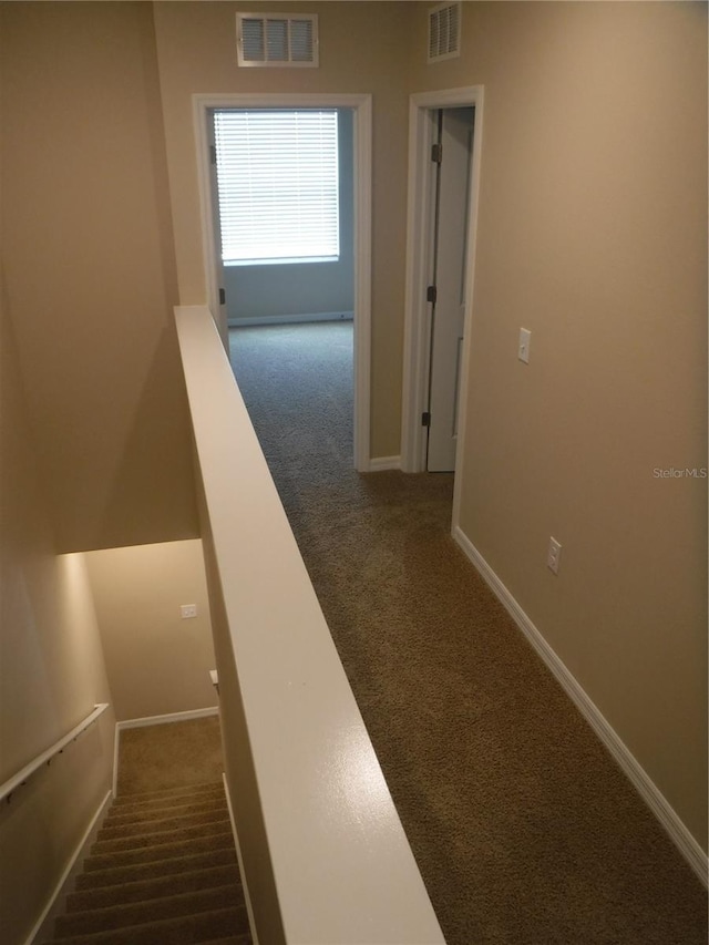 hallway with dark colored carpet