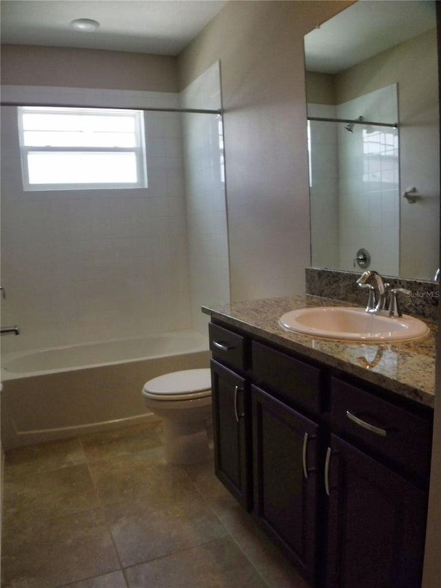 full bathroom with vanity, tiled shower / bath, tile patterned floors, and toilet