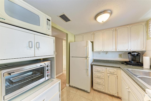 kitchen with sink, white appliances, decorative backsplash, and light tile patterned floors