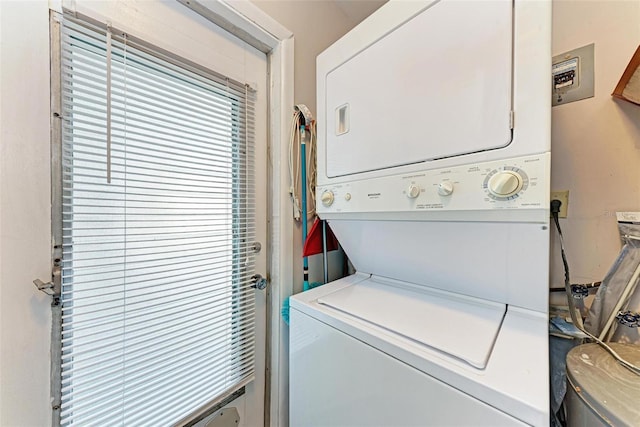 clothes washing area featuring stacked washer / dryer