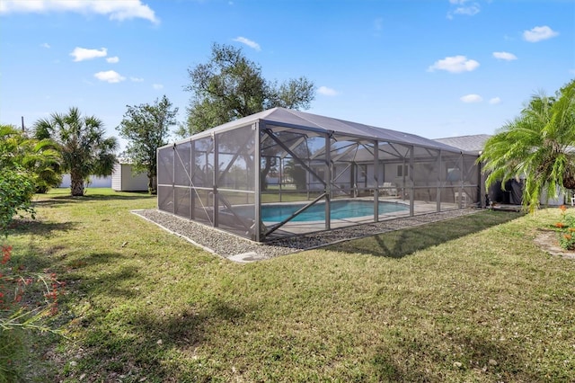 view of swimming pool with a shed, a yard, and a lanai