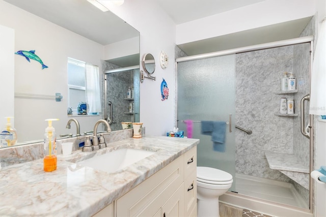 bathroom featuring vanity, toilet, and a shower with shower door