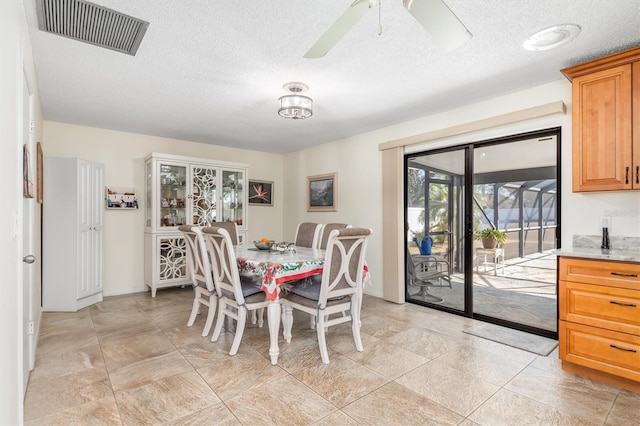 dining space featuring ceiling fan and a textured ceiling