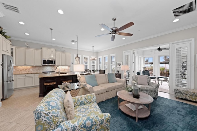 living room featuring ornamental molding, sink, and light tile patterned floors