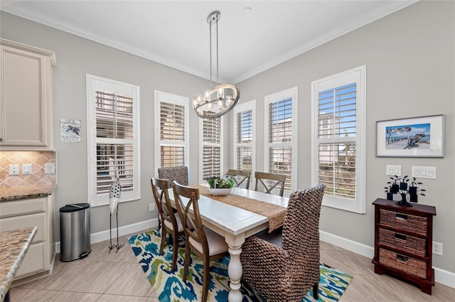 tiled dining space featuring crown molding and a chandelier