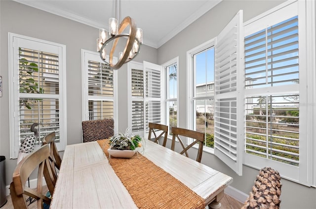 dining area with crown molding, plenty of natural light, and an inviting chandelier