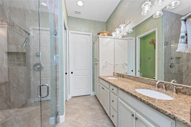 bathroom with a shower with door, vanity, and tile patterned floors