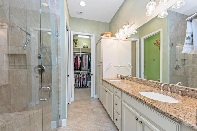 bathroom with vanity, an enclosed shower, and tile patterned flooring