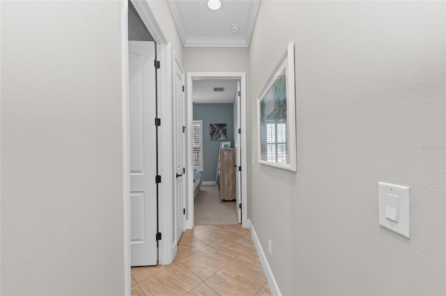 hallway featuring crown molding and light tile patterned floors