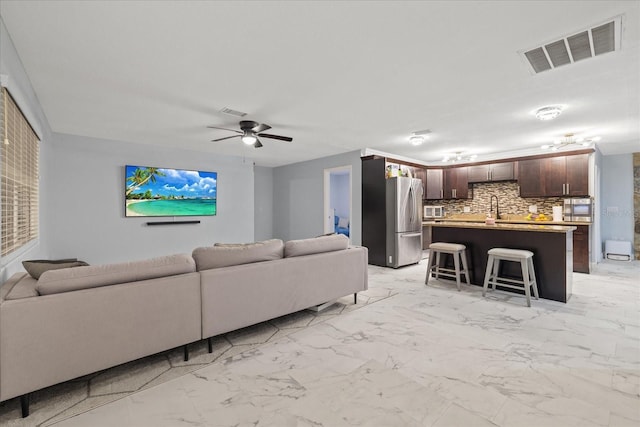 living room featuring sink and ceiling fan