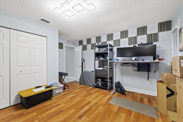 office with wood-type flooring and a textured ceiling