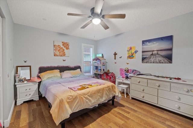 bedroom with ceiling fan, a textured ceiling, and light hardwood / wood-style floors