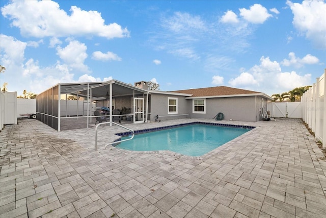 view of pool featuring glass enclosure and a patio area