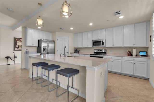 kitchen featuring sink, white cabinetry, hanging light fixtures, an island with sink, and stainless steel appliances