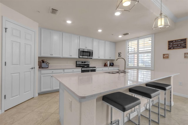 kitchen with stainless steel appliances, sink, and a center island with sink