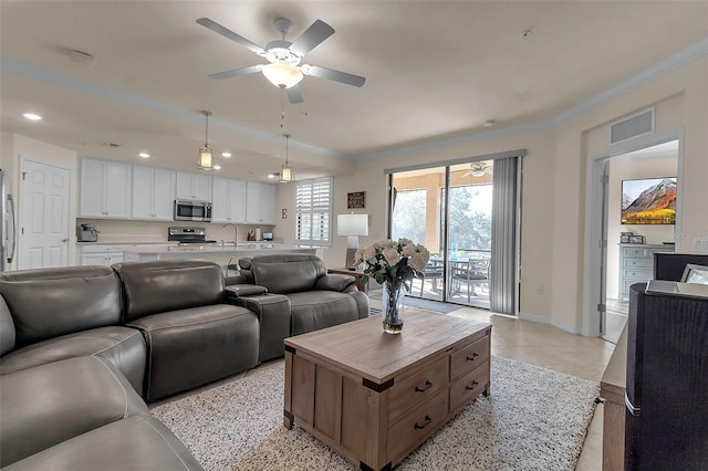 living room with crown molding, sink, and ceiling fan