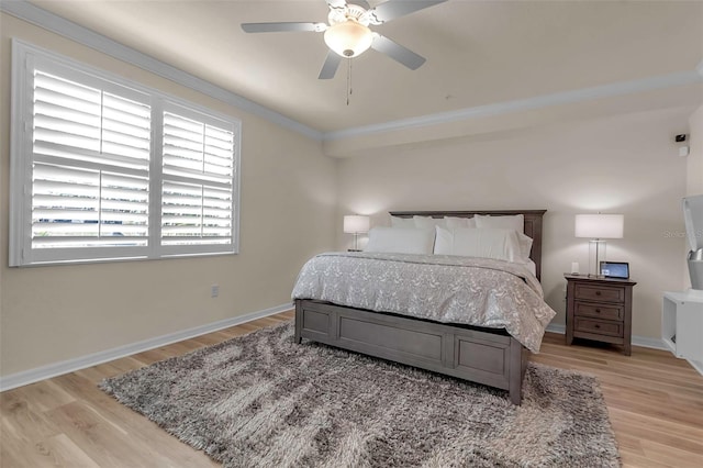 bedroom with ornamental molding, ceiling fan, and light hardwood / wood-style floors