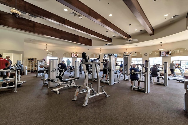 gym featuring a towering ceiling and ceiling fan