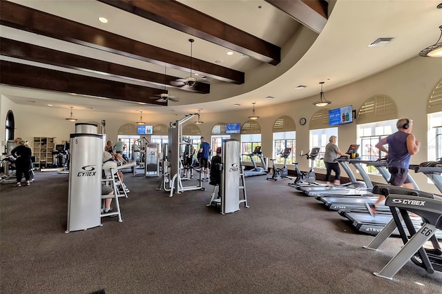 exercise room with a towering ceiling and ceiling fan