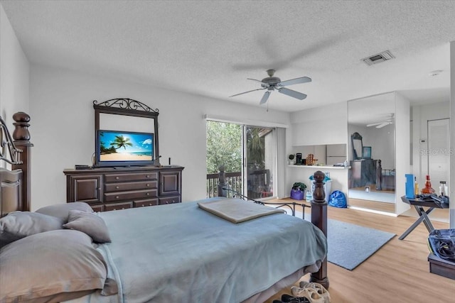 bedroom with ceiling fan, a textured ceiling, access to outside, and light wood-type flooring