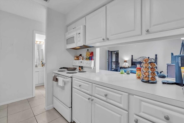 kitchen featuring light tile patterned flooring, white appliances, and white cabinetry